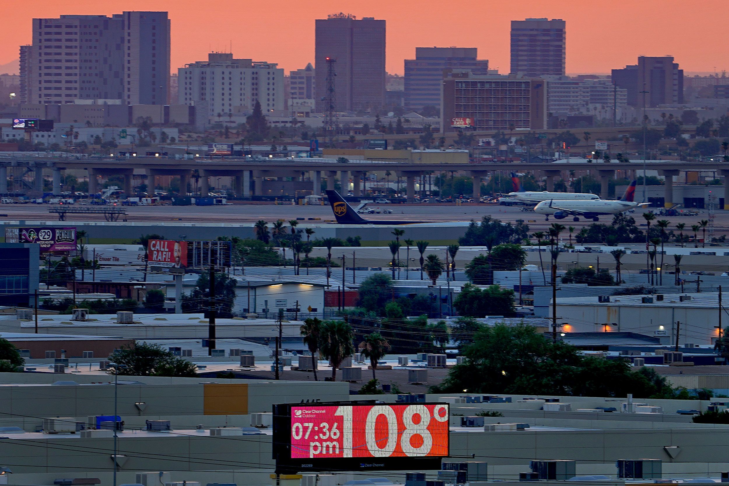 A sign displays the temperature on July 12 as jets taxi at Phoenix's Sky Harbor International Airport.