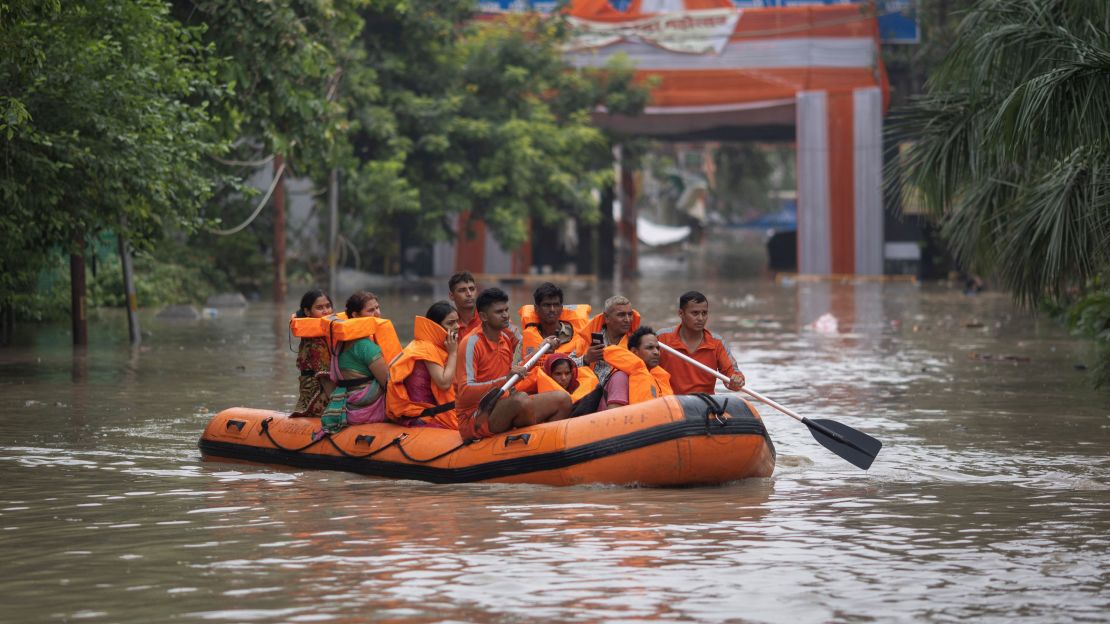 Members of the National Disaster Response Force (NDRF) evacuate stranded residents from a flooded locality, after a rise in the water level of the Yamuna River, in New Delhi on July 13, 2023.