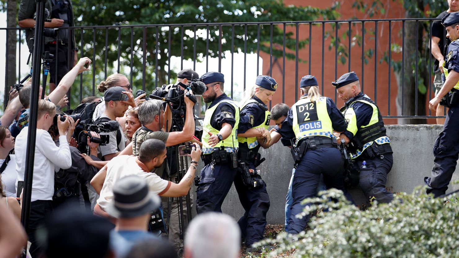 Police officers seen as demonstrators burn the Quran outside Stockholm's central mosque in Stockholm, Sweden, on June 28, 2023.