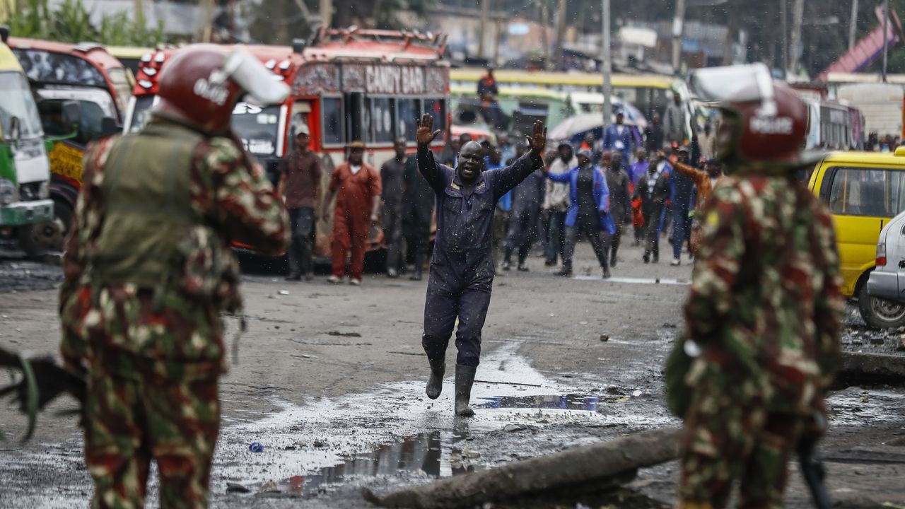 A protester raises his hands as he walks towards riot police during protests in the capital Nairobi, Kenya Friday, July 7, 2023.