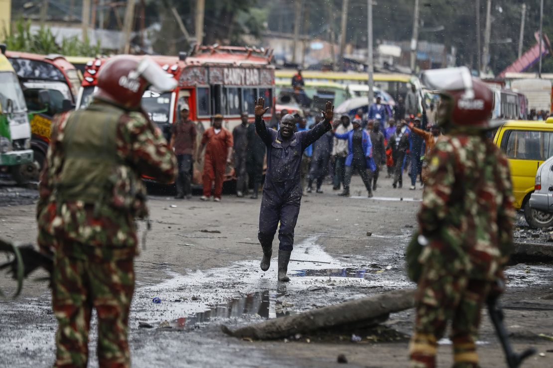 A protester raises his hands as he walks towards riot police during protests in the capital Nairobi, Kenya Friday, July 7, 2023.