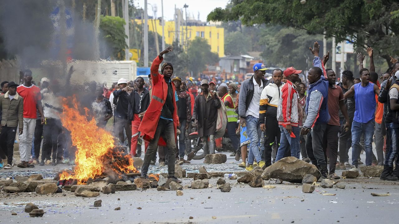 Protesters stand by a burning barricade on a street in the Mathare neighborhood of Nairobi.