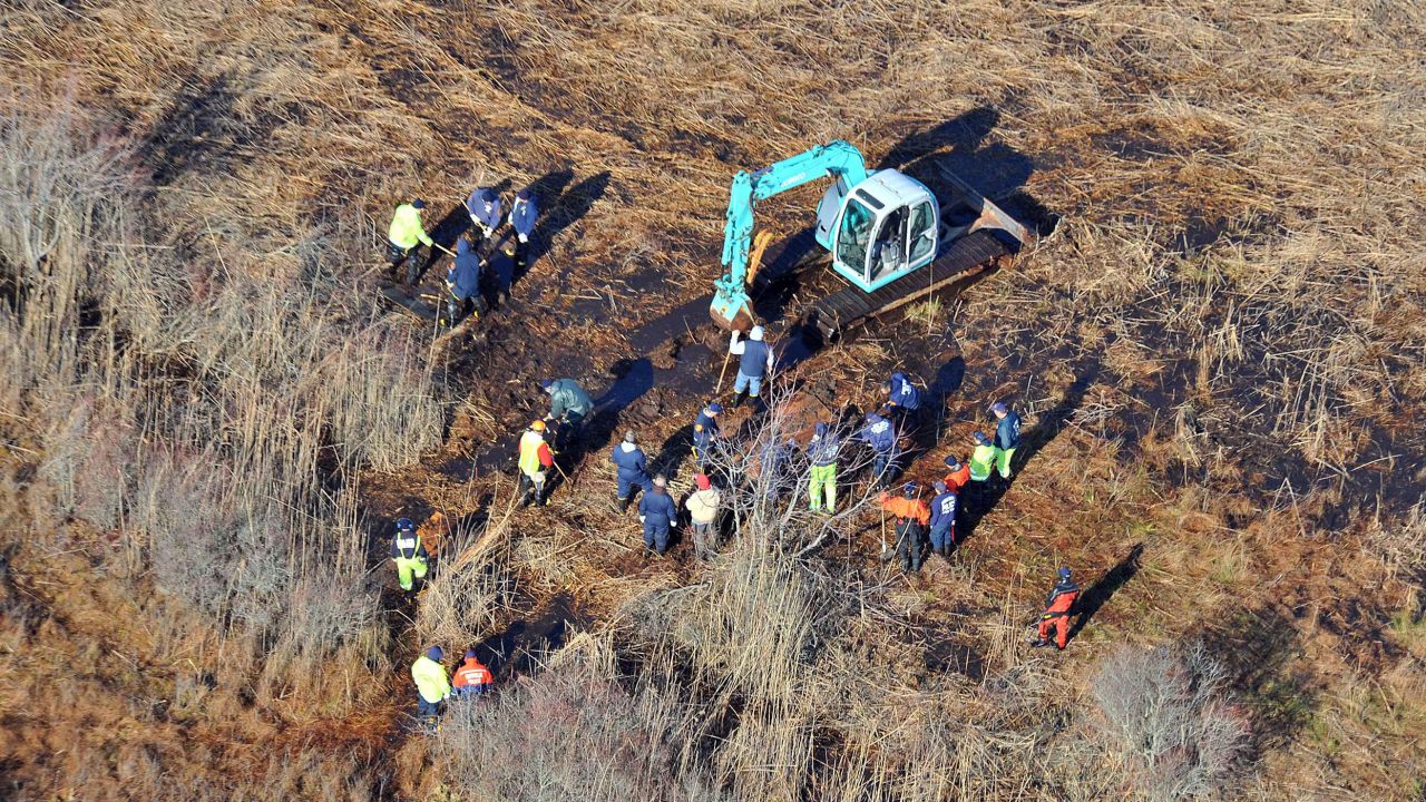 FILE - In this Dec. 8, 2011 photo, investigators use a backhoe to dig while searching for Shannan Gilbert's body in different sectors of a marsh area just east of Oak Beach, N.Y. A Long Island architect has been charged, Friday, July 14, 2023, with murder in the deaths of three of the 11 victims in a long-unsolved string of killings known as the Gilgo Beach murders. (AP Photo/Kevin P. Coughlin, File)