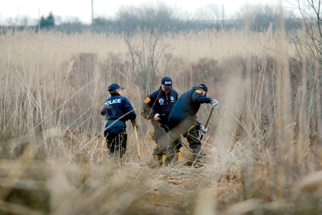 Crime scene investigators use metal detectors to search a marsh for the remains of Shannan Gilbert on December 12, 2011, in Oak Beach, New York.