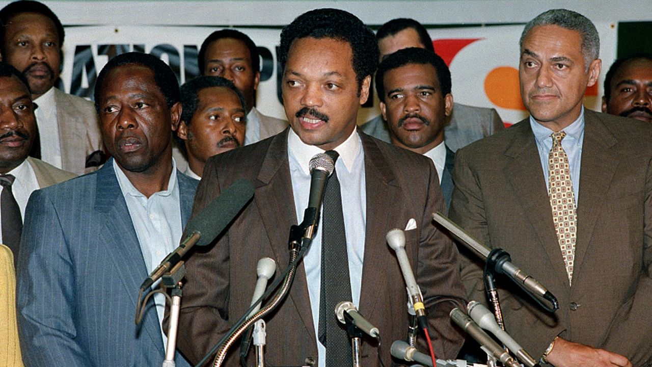 Rev. Jesse Jackson, center, is joined by baseball great Hank Aaron, left, at a meeting of Operation PUSH at the Sheraton in Rosemont, Illinois, Monday, June 29, 1987.
