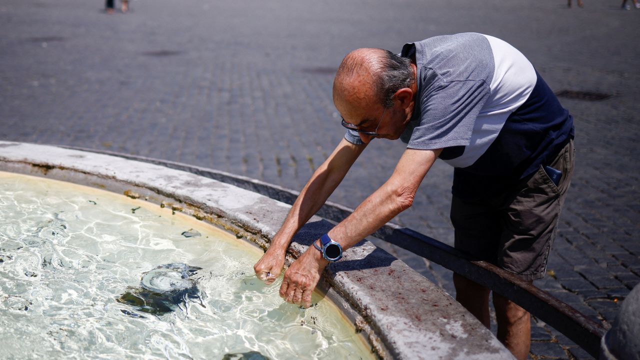 A man cools off at a fountain at Piazza del Popolo in Rome. 