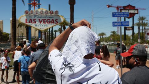 Satya Soviet Patnaik shields himself from the sun while waiting in line to take a photo at the historic Welcome to Las Vegas Sign during a heat wave in Las Vegas, Nevada, on July 14, 2023. Climate scientists are sounding alarm about the impact of human-caused global warming, and warning 2023 is on track to be the warmest since records began. Global surface temperatures have increased by about 2F (1.1C) since 1880, making extreme heat more frequent. Extreme heat is the deadliest weather hazard in the United States, according to official data, with the elderly, the very young, people with mental illness and chronic diseases at highest risk. 