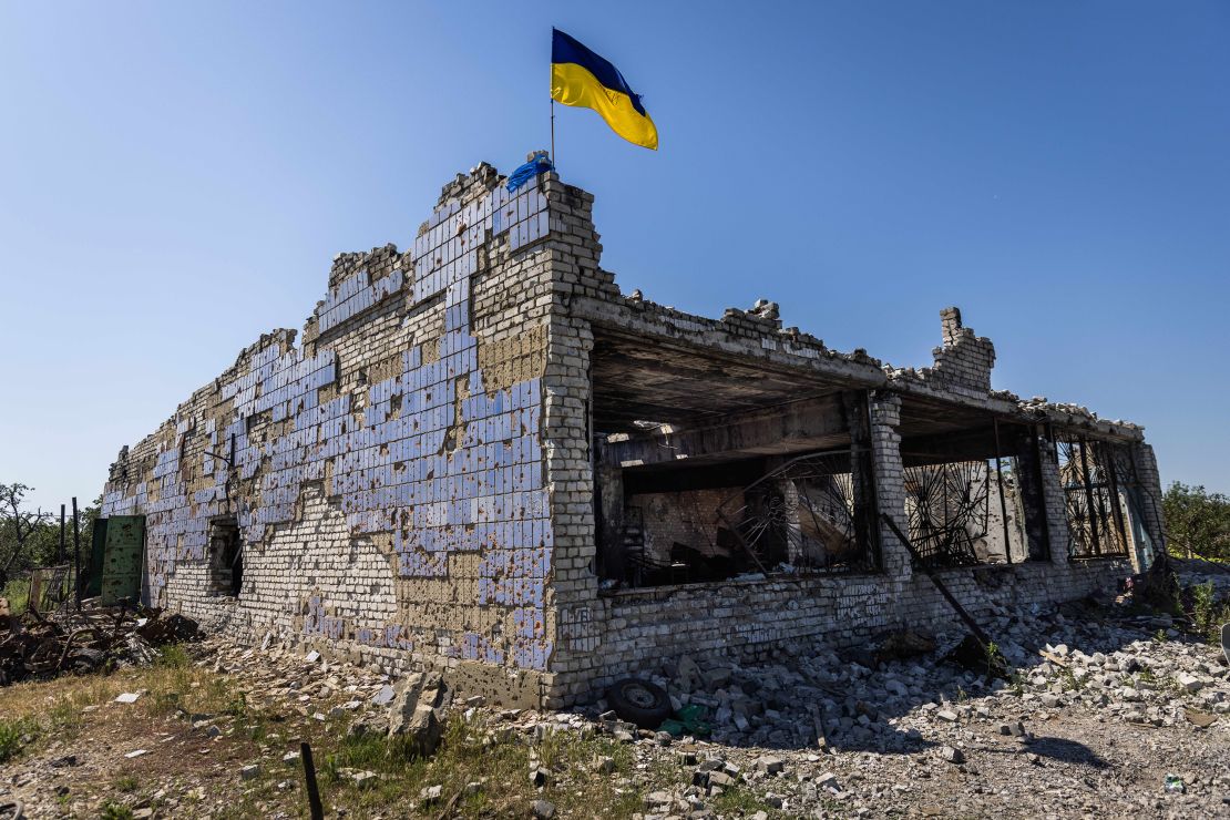 A Ukrainian flag waves above a destroyed building after shelling in Vremivka, Ukraine, on July 6.