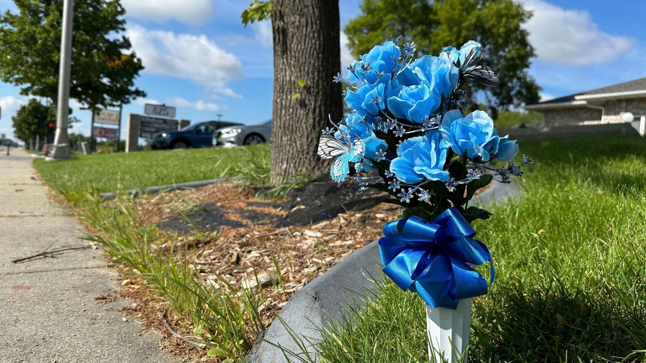 Flowers rest near the site where one police officer was fatally shot and two others were critically wounded Friday.
