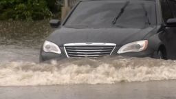 A car drives through floodwaters in Waterbury, Connecticut.