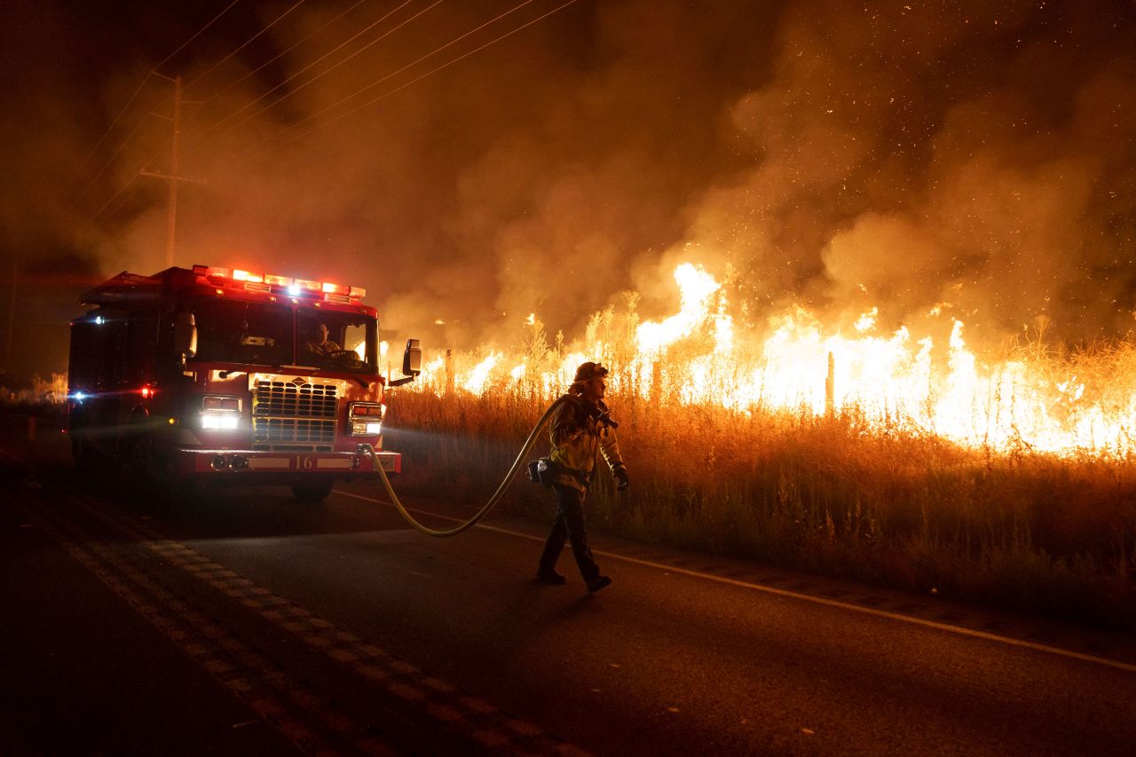 A firefighter watches flames from the <a href="https://www.cnn.com/2023/07/16/us/california-wildfires-extreme-heat/index.html" target="_blank">Rabbit Fire</a> approach Gilman Springs Road in Moreno Valley, California, on July 14.