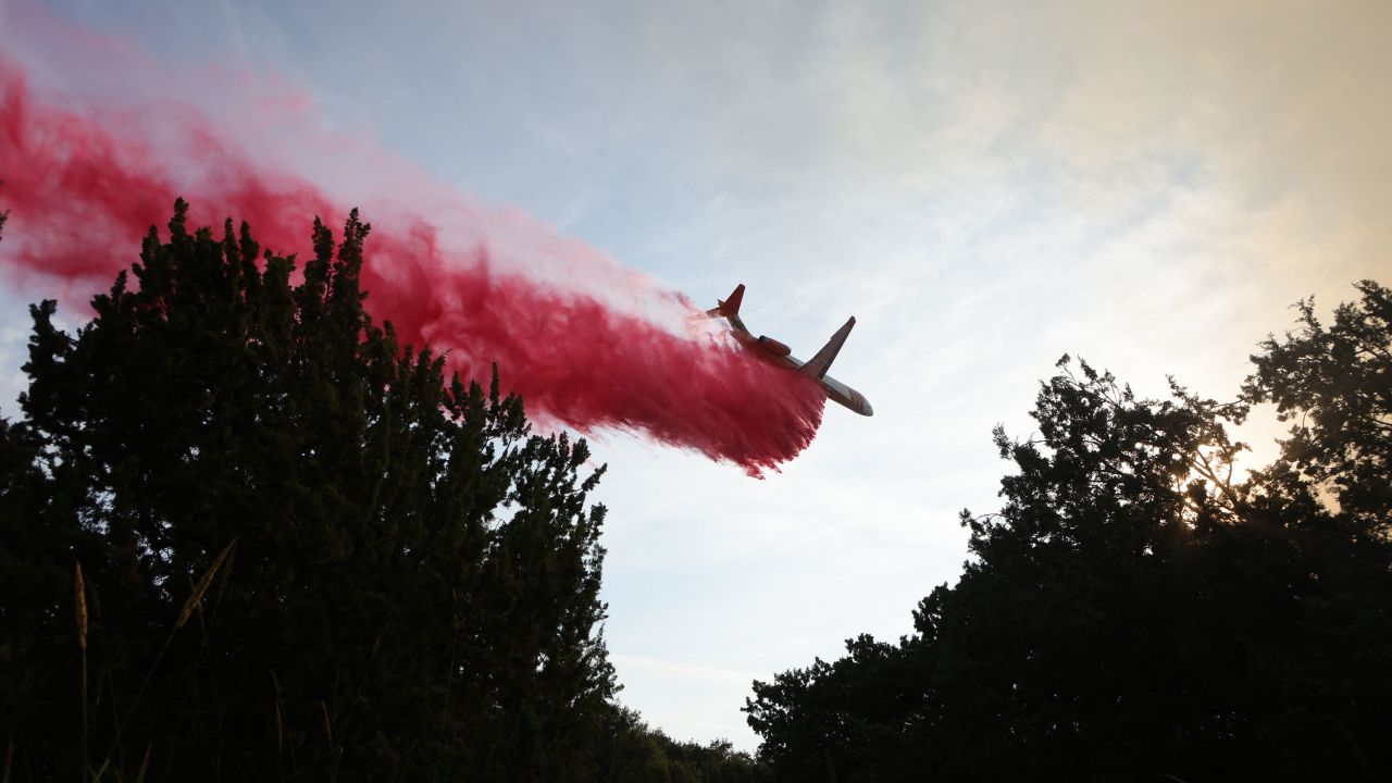 An aircraft drops fire retardant as firefighters work to control the Gavilan Fire in Riverside County, California, on July 15, 2023.