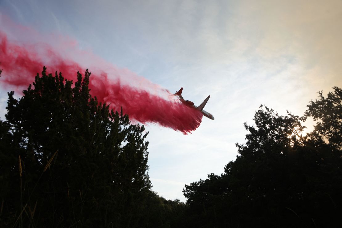 An aircraft drops fire retardant as firefighters work to control the Gavilan Fire in Riverside County, California, on July 15, 2023.