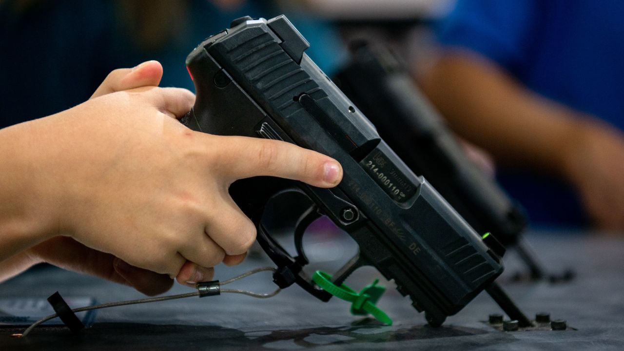 In this May 2022 photo, a 7-year-old child picks up a handgun at the George R. Brown Convention Center during the National Rifle Association annual convention in Houston, Texas.