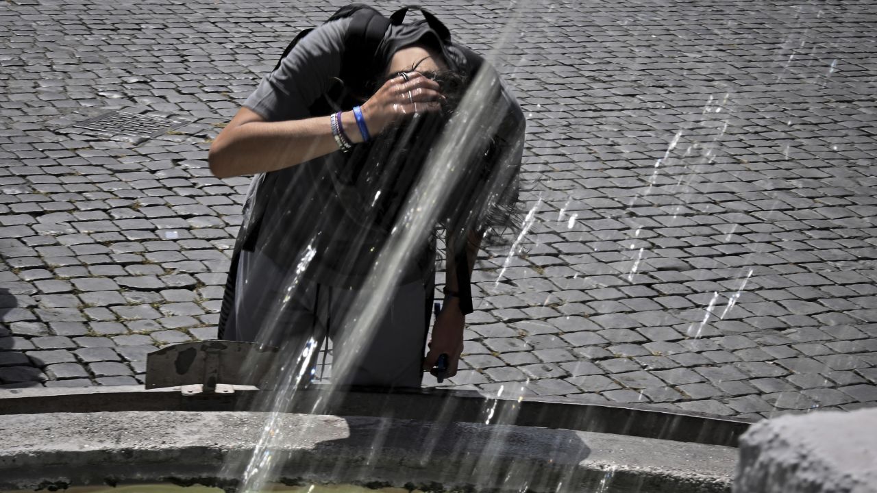 A boy cools down at the Piazza del Popolo fountain in Rome on July 17, 2023.