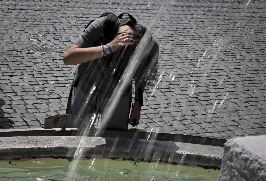 A boy cools down at the Piazza del Popolo fountain in Rome on July 17, 2023.