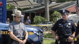 New York State police officers stand guard as law enforcement searches the home of Rex Heuermann, Saturday, July 15, 2023, in Massapequa Park, N.Y. Heuermann, a Long Island architect, was charged Friday, July 14, with murder in the deaths of three of the 11 victims in a long-unsolved string of killings known as the Gilgo Beach murders. (AP Photo/Jeenah Moon)