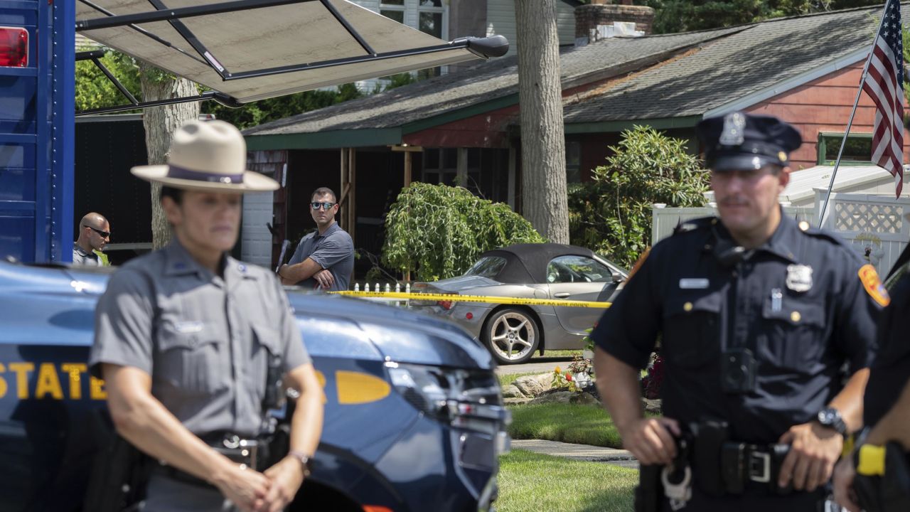 New York State police officers stand guard as law enforcement searches the home of Rex Heuermann, Saturday, July 15, 2023, in Massapequa Park, N.Y. Heuermann, a Long Island architect, was charged Friday, July 14, with murder in the deaths of three of the 11 victims in a long-unsolved string of killings known as the Gilgo Beach murders. (AP Photo/Jeenah Moon)