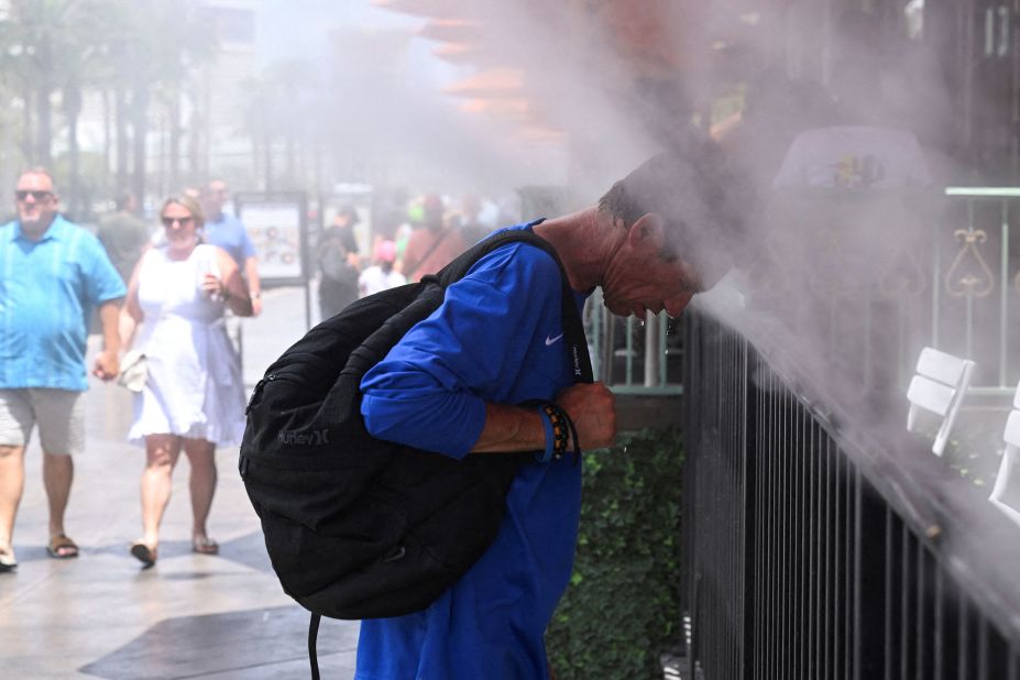 A man in Las Vegas puts his head in misters to cool off on July 17.
