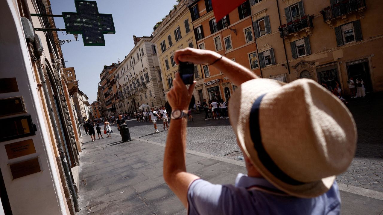 A man takes a photo of a sign showing the temperature, near the Spanish Steps, during a heat wave across Italy as temperatures are expected to rise further in the coming days, in Rome, Italy July 17, 2023. REUTERS/Guglielmo Mangiappane