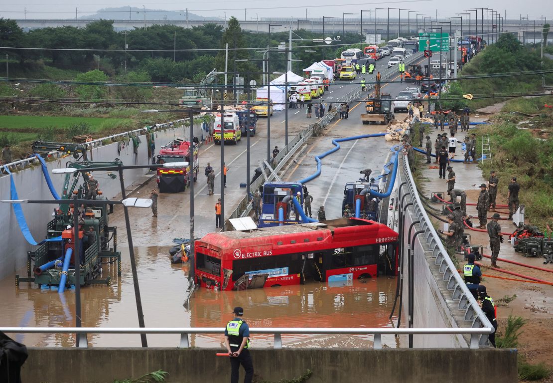 Rescue workers near an underpass submerged by a flooded river in Cheongju, South Korea, on Sunday.