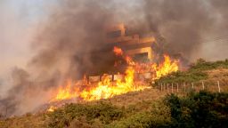 Flames engulf a house as a wildfire burns in Saronida, near Athens, Greece, July 17, 2023. REUTERS/Stelios Misinas
