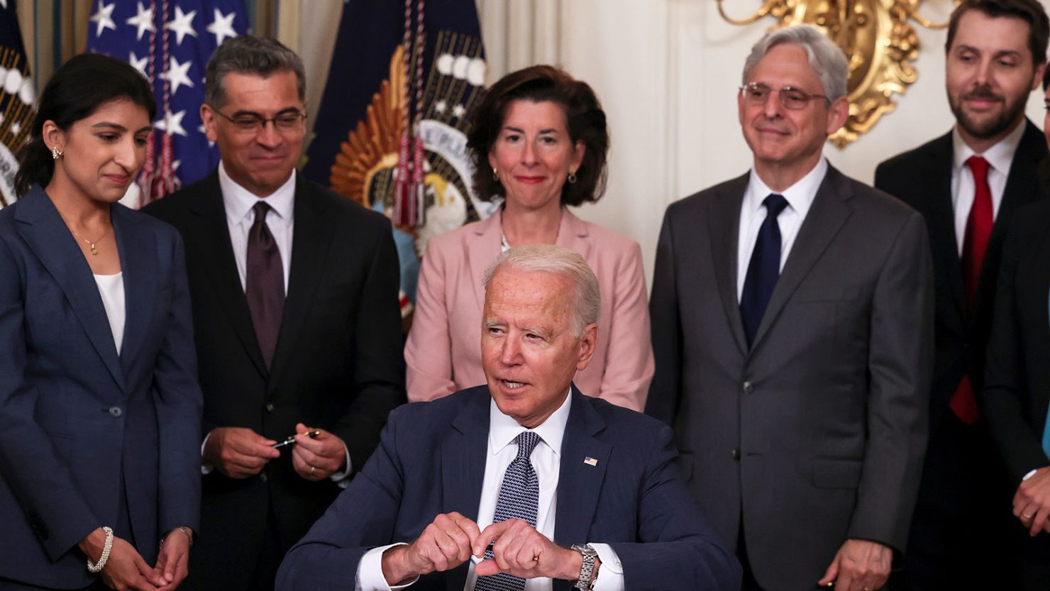 U.S. President Joe Biden signs an executive order on "promoting competition in the American economy" as members of his Cabinet standby in the State Dining Room at the White House in Washington U.S., July 9, 2021.