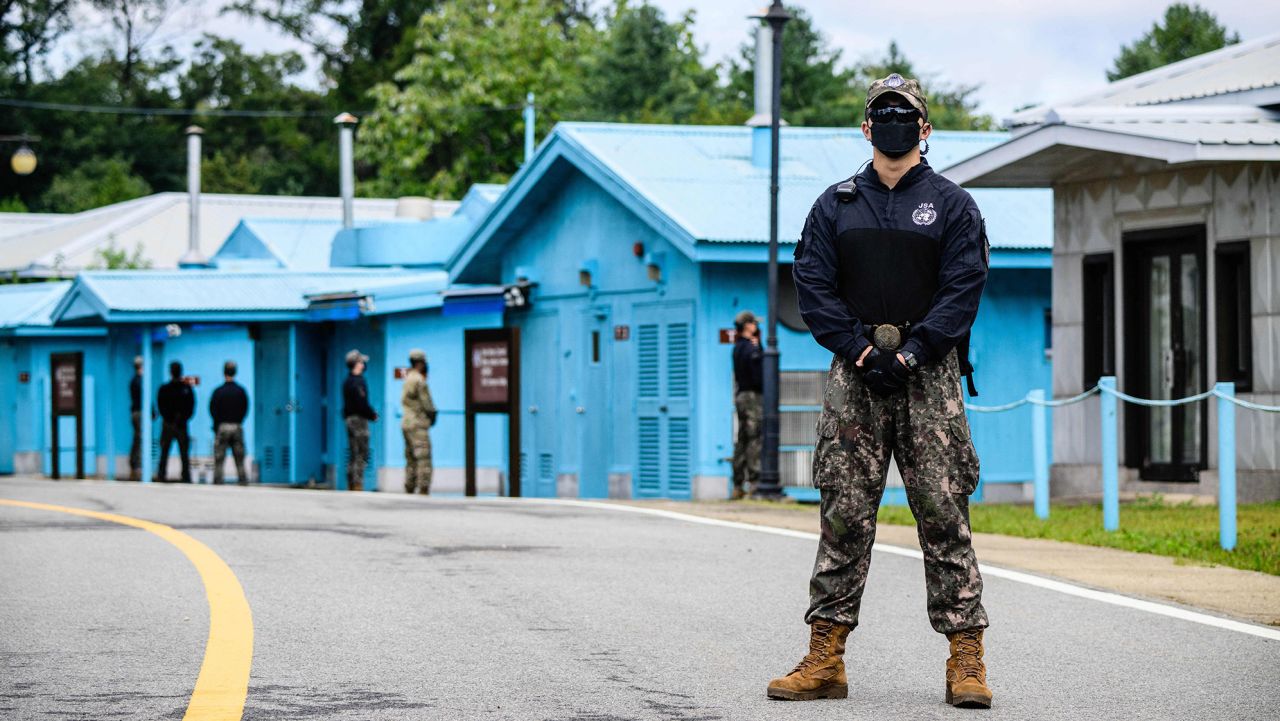 South Korean soldier (R) and UNC (United Nations Command) soldier (background, in green) stand guard near the military demarcation line (not seen) separating North and South Korea, at the Joint Security Area (JSA) of the Demilitarized Zone (DMZ) in the truce village of Panmunjom  on October 4, 2022. - North Korea fired a mid-range ballistic missile on October 4, which flew over Japan, Seoul and Tokyo said, a significant escalation as Pyongyang ramps up its record-breaking weapons-testing blitz. (Photo by ANTHONY WALLACE / AFP) (Photo by ANTHONY WALLACE/AFP via Getty Images)