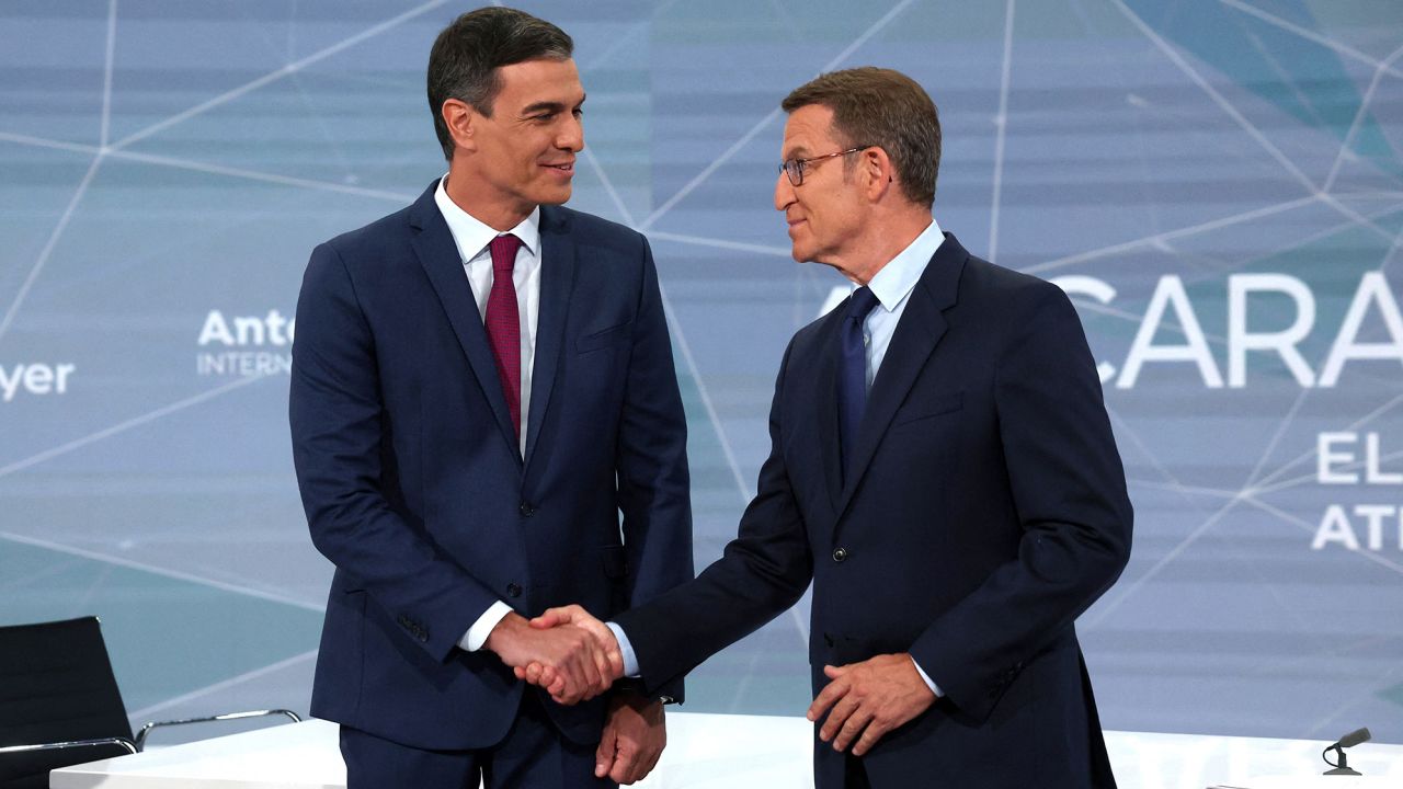 Prime Minister Pedro Sanchez and PP leader Alberto Nunez Feijóo shake hands before a TV debate.