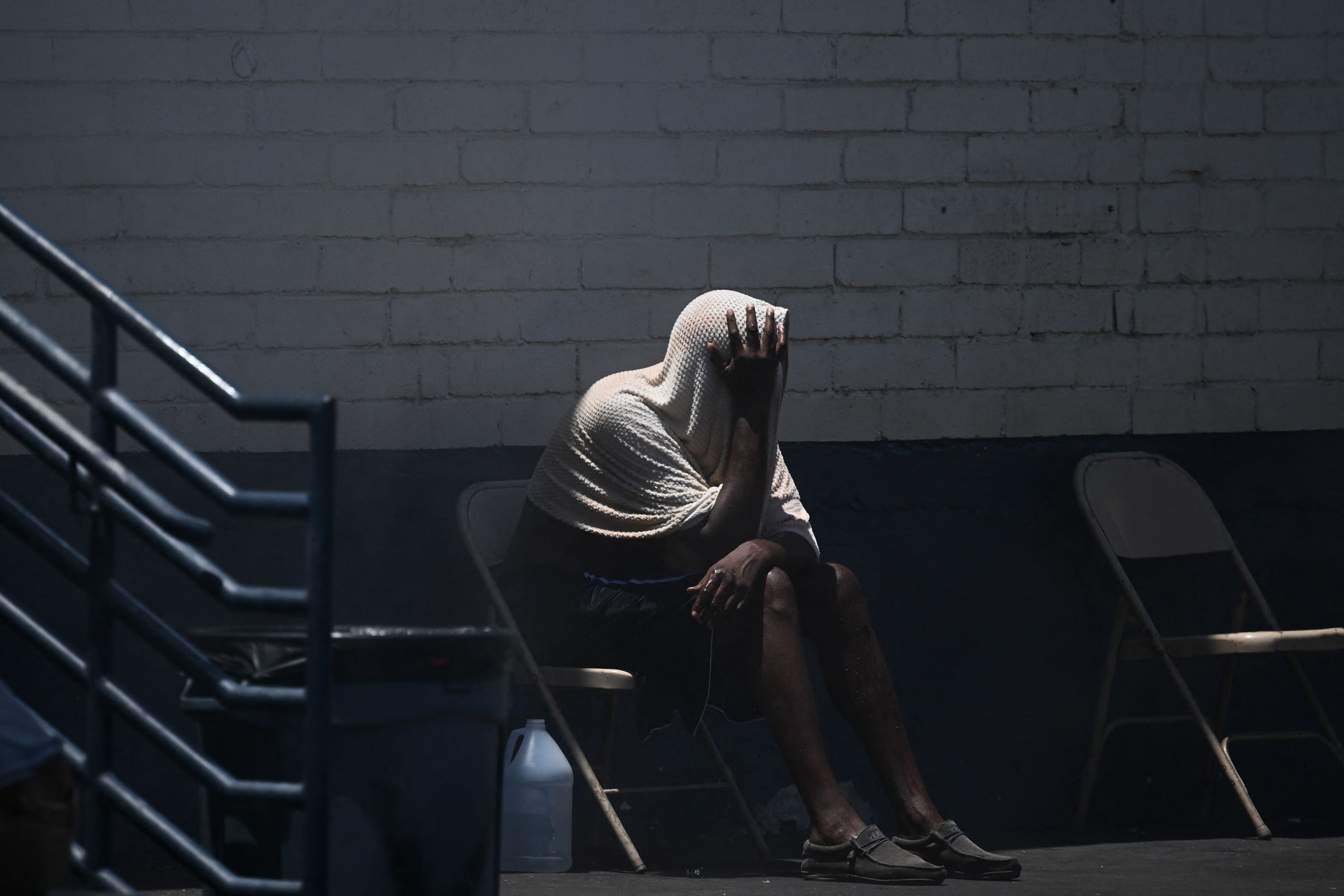 A person covers their head while trying to stay cool in "The Zone," a vast homeless encampment where hundreds of people reside in Phoenix, on July 18.