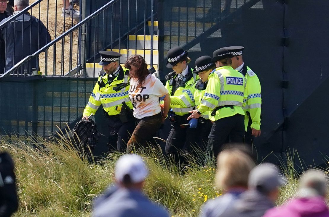 A Just Stop Oil protester is taken away by Police during day two of The Open at Royal Liverpool, Wirral. Picture date: Friday July 21, 2023.