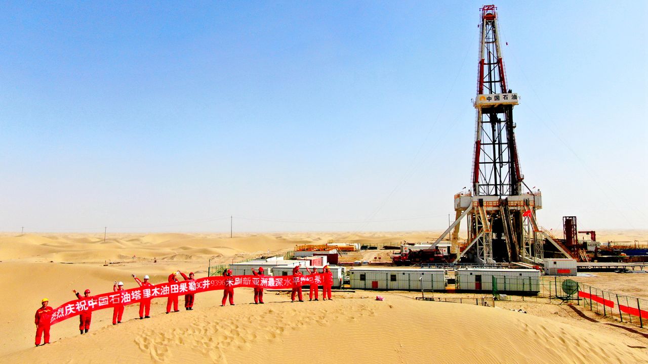 Oil workers hold a banner at Tarim Oilfield at Taklimakan Desert in Shaya County on March 9, 2023 in the Xinjiang Uygur Autonomous Region of China.
