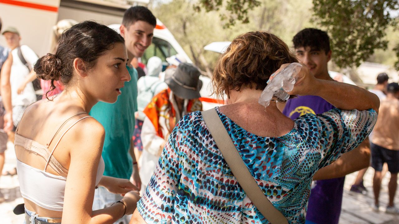 Atina'nın merkezindeki Akropolis'in girişinde bir turist buz küpleriyle serinliyor. 