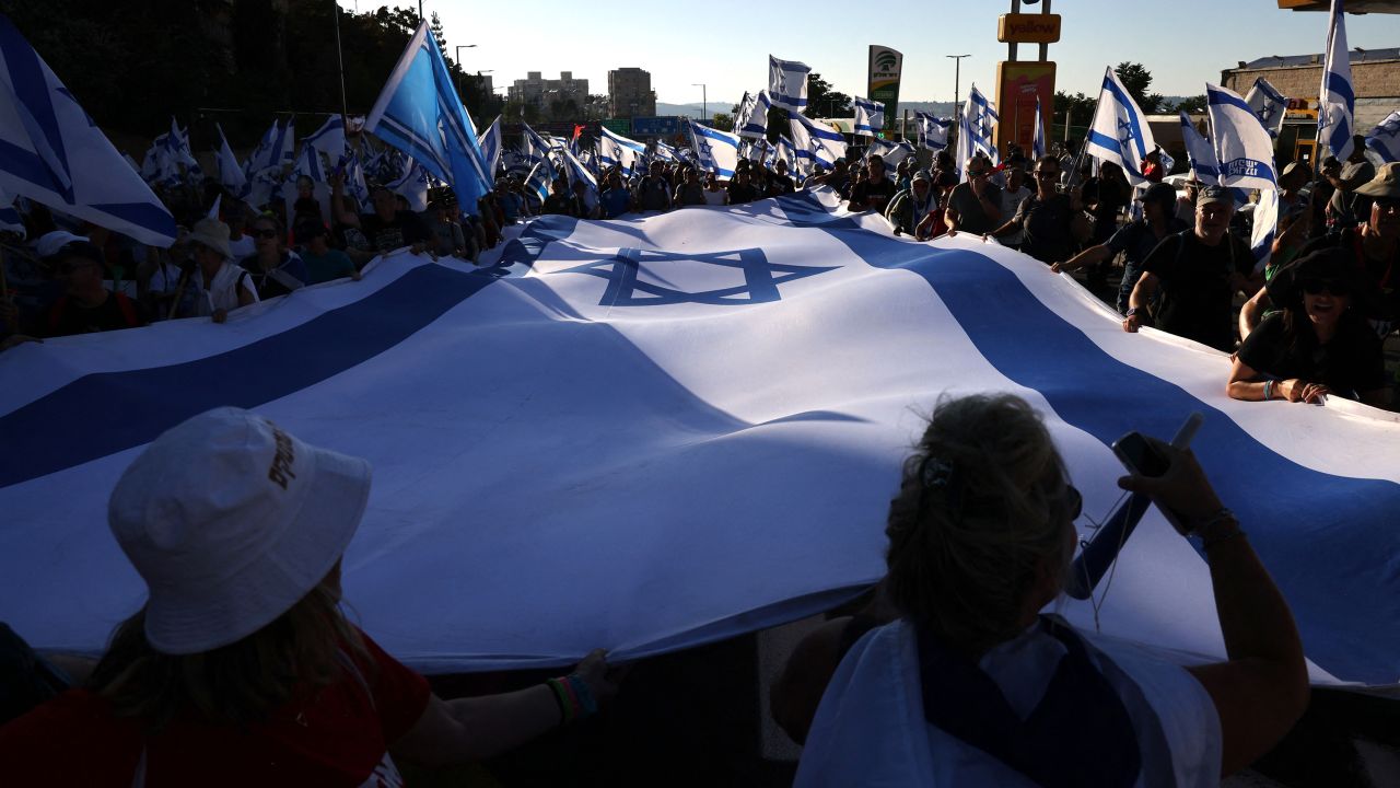 Demonstrators wave an Israeli flag as they march into Jerusalem.