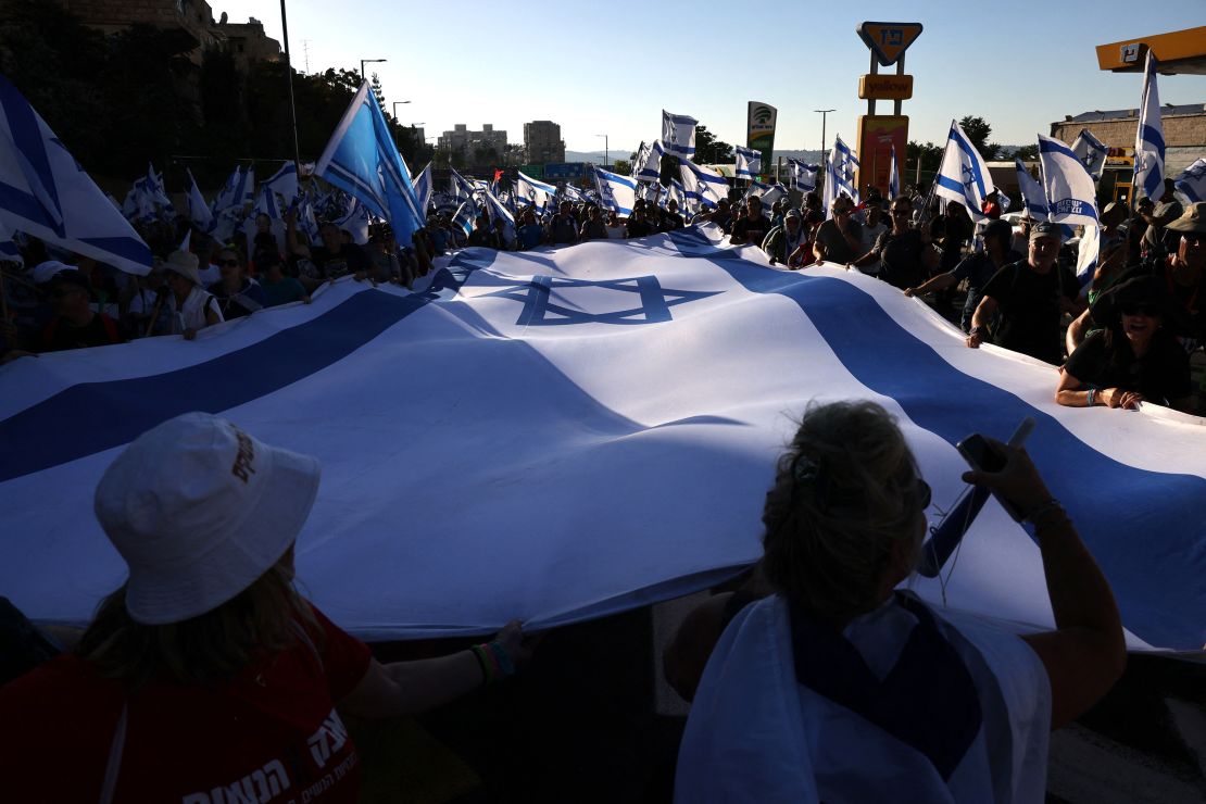 Demonstrators wave an Israeli flag as they march into Jerusalem.