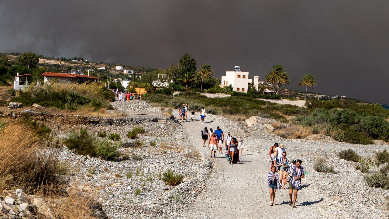 Tourists are being evacuated as wildfire burns near Lindos, on the island of Rhodes, Greece, July 22, 2023. 