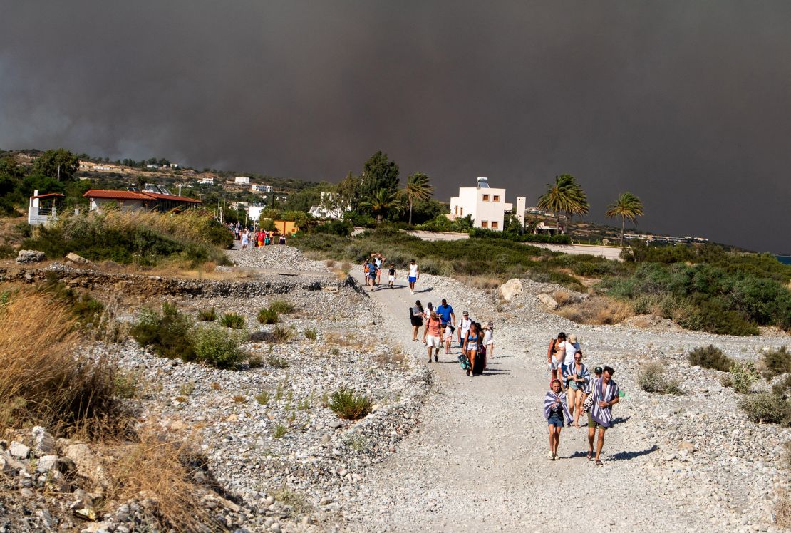 Tourists are being evacuated as wildfire burns near Lindos, on the island of Rhodes, Greece, July 22, 2023.
