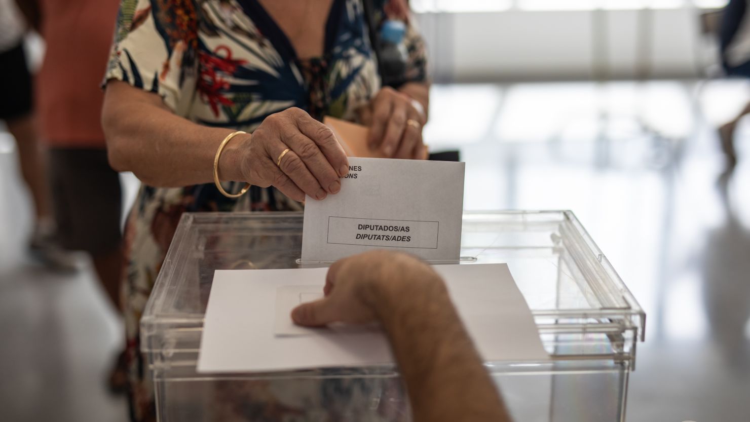 A woman places her vote in the ballot box at Leonor Canalejas Public School on July 23, 2023 in Benidorm, Spain. Voters in Spain head to the polls on July 23 to cast their votes and elect Spain's next government. 