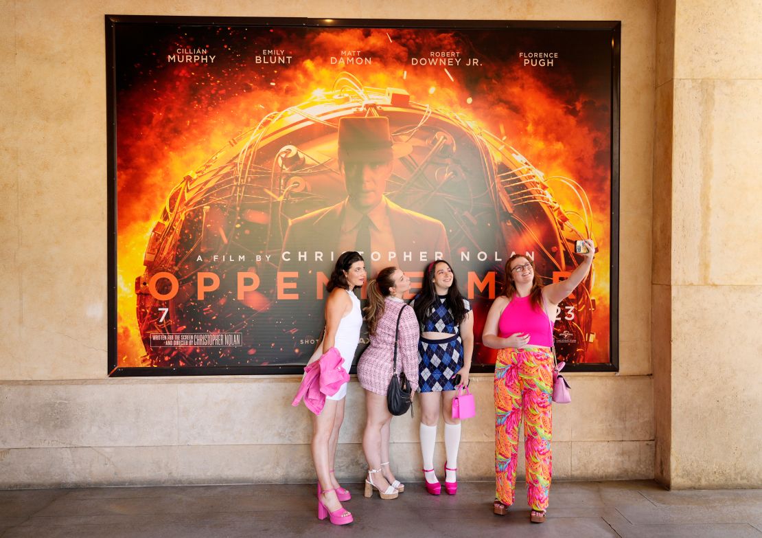From left, Gabrielle Roitman, Kayla Seffing, Maddy Hiller and Casey Myer take a selfie in front of an "Oppenheimer" movie poster before they attended an advance screening of "Barbie" on Thursday in Los Angeles. 