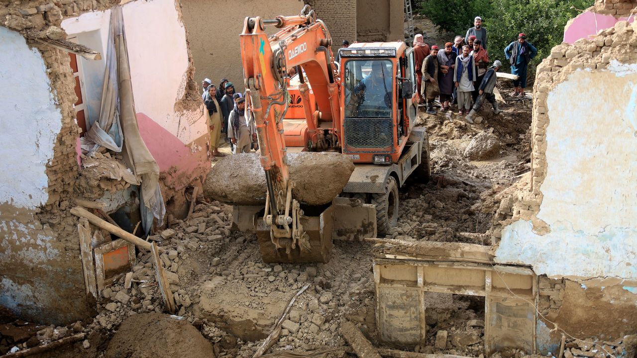 An excavator removes mud and rocks from a damaged house after heavy flooding in Maidan Wardak province.