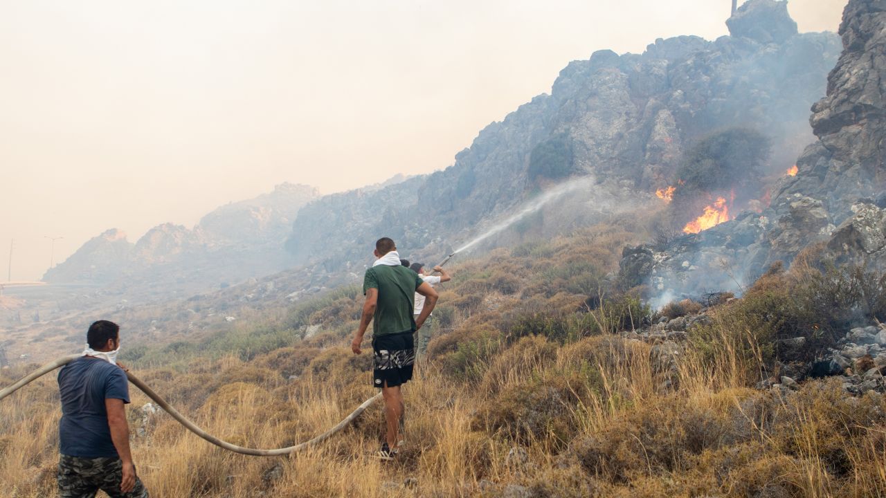 Firefighter teams intervene a wildfire across Greece's Rhodes island on July 22, 2023, as Greece grapples with a severe heat wave.