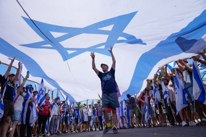 Demonstrators wave a large Israeli flag during a protest outside the Knesset on July 24.
