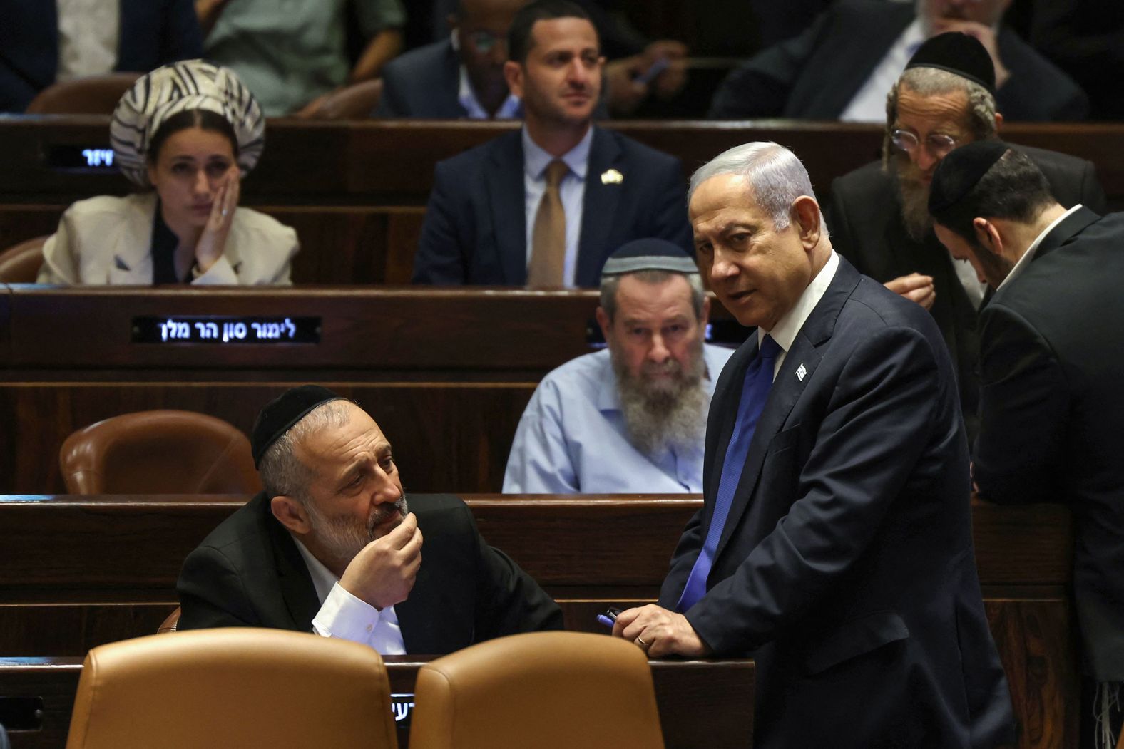 Israeli Prime Minister Benjamin Netanyahu, right, speaks with Aryeh Deri, chairman of the ultra-Orthodox party Shas, during a Knesset session on July 24.