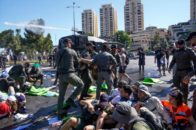 Israeli police disperse protesters blocking the road leading to the Knesset on July 24. Protesters were met with water cannons, fences and barbed wire as they attempted to block access to the building.