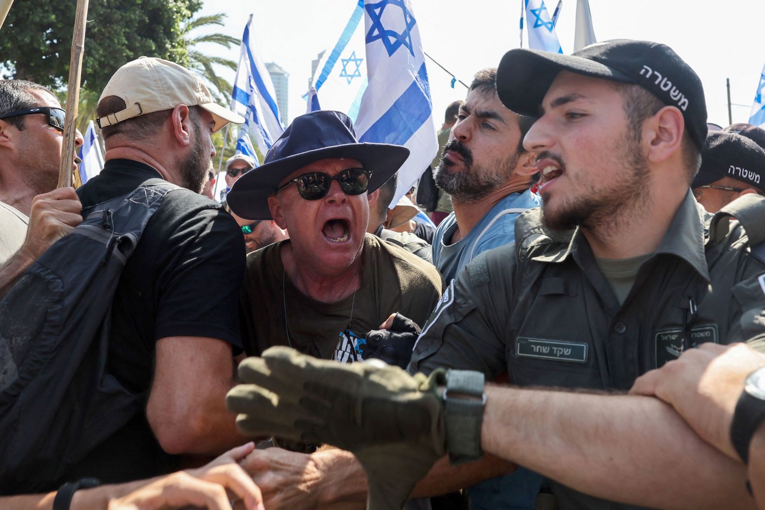 Members of Israel's security forces scuffle with demonstrators in Tel Aviv on July 18.