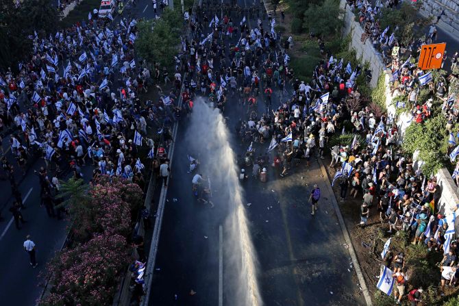 Israeli security forces use a water cannon to disperse protesters blocking the entrance of the Knesset on July 24.