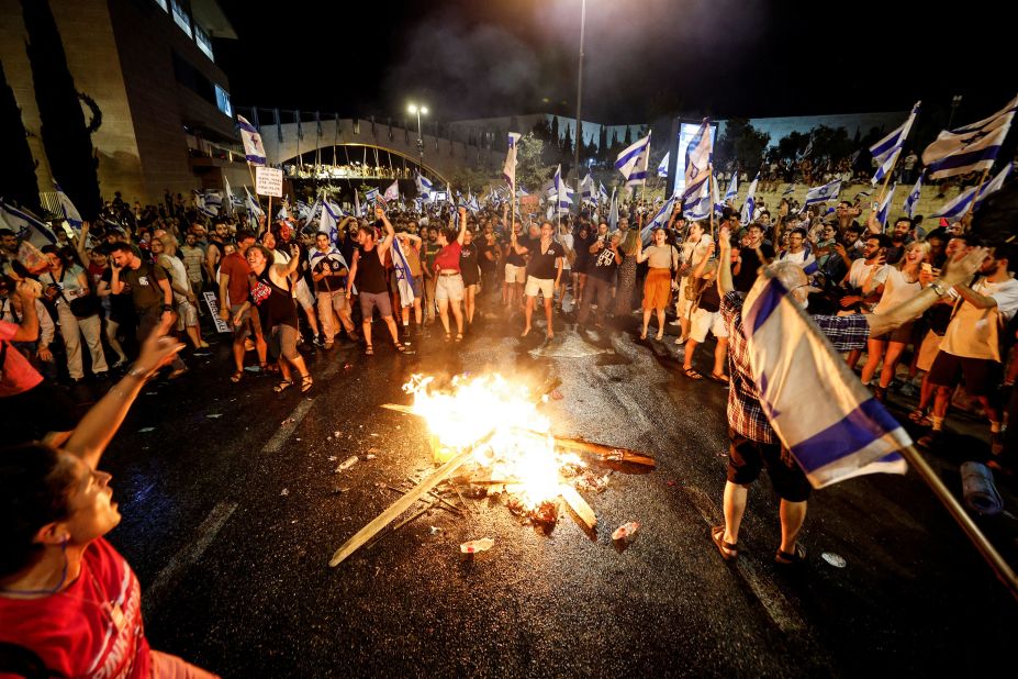 Protesters demonstrate around a fire near the Knesset in Jerusalem, on Monday, July 24.
