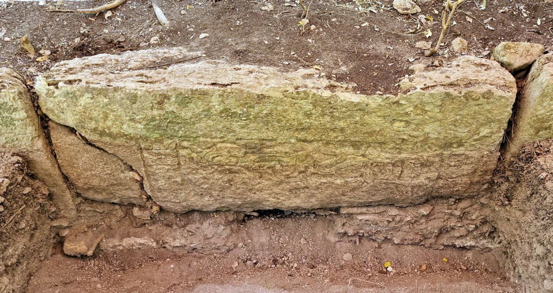 A stone block with a relief, reused in a stairway in the city of Ocumtun.