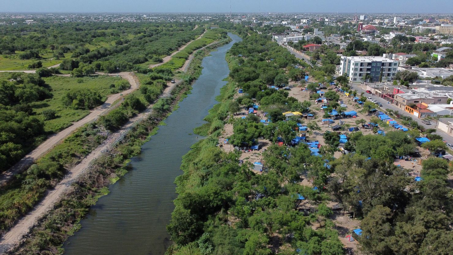 A makeshift camp, where asylum-seekers wait as they attempt to cross into the US by an appointment through the Customs and Border Protection app, lines the Rio Grande river border. 