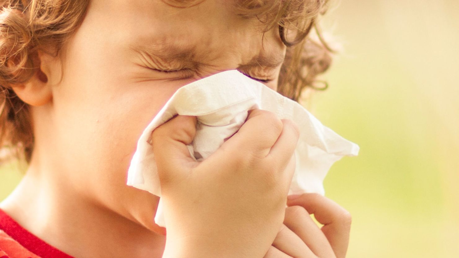 Boy sneezes due to allergies